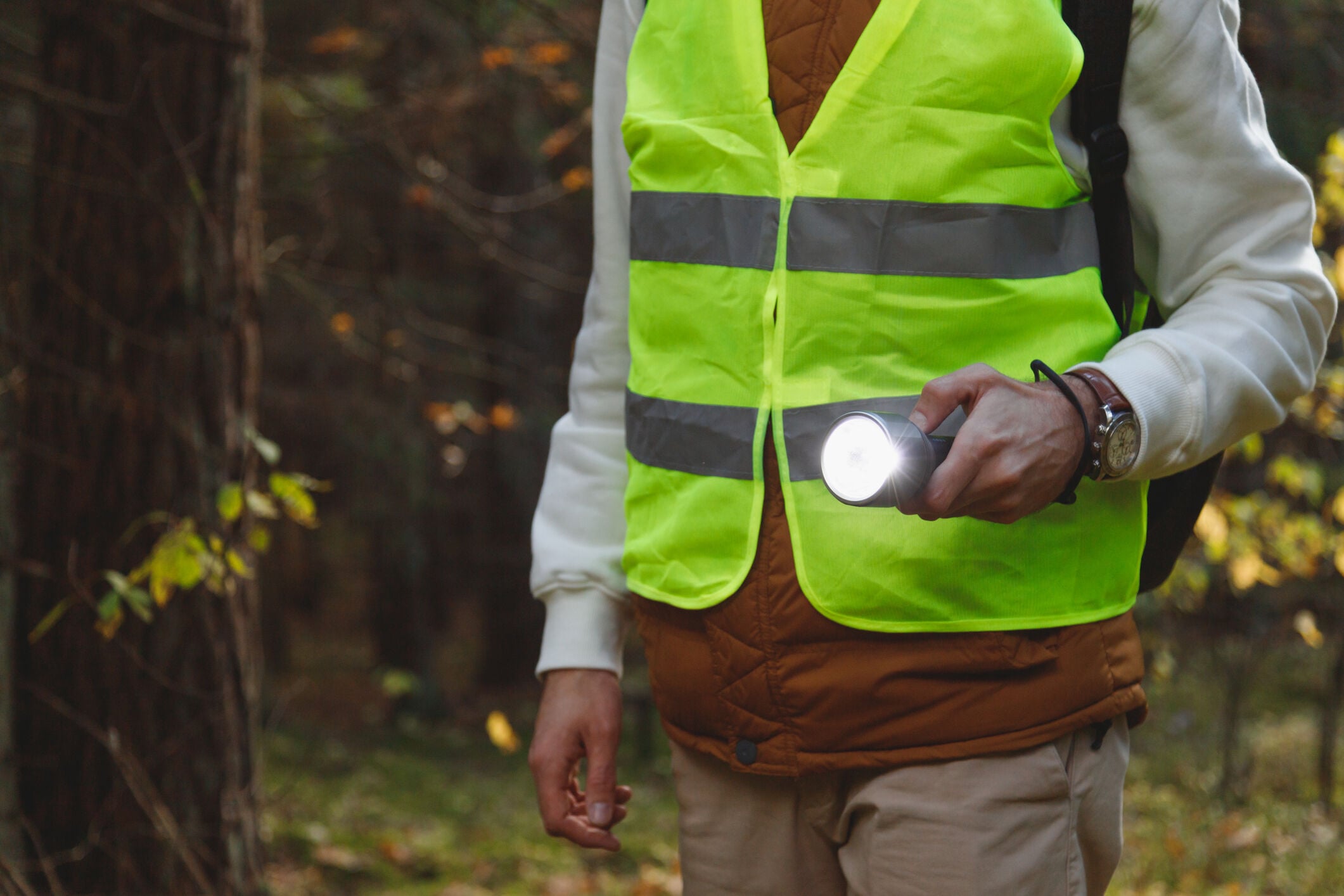 man met zaklamp en reflecterend vest